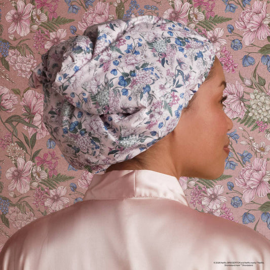 Person wearing a floral-patterned headscarf against a floral background