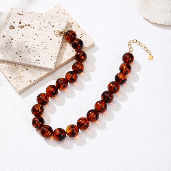 Chunky tortoise bead necklace with glossy amber and dark brown round acrylic beads.