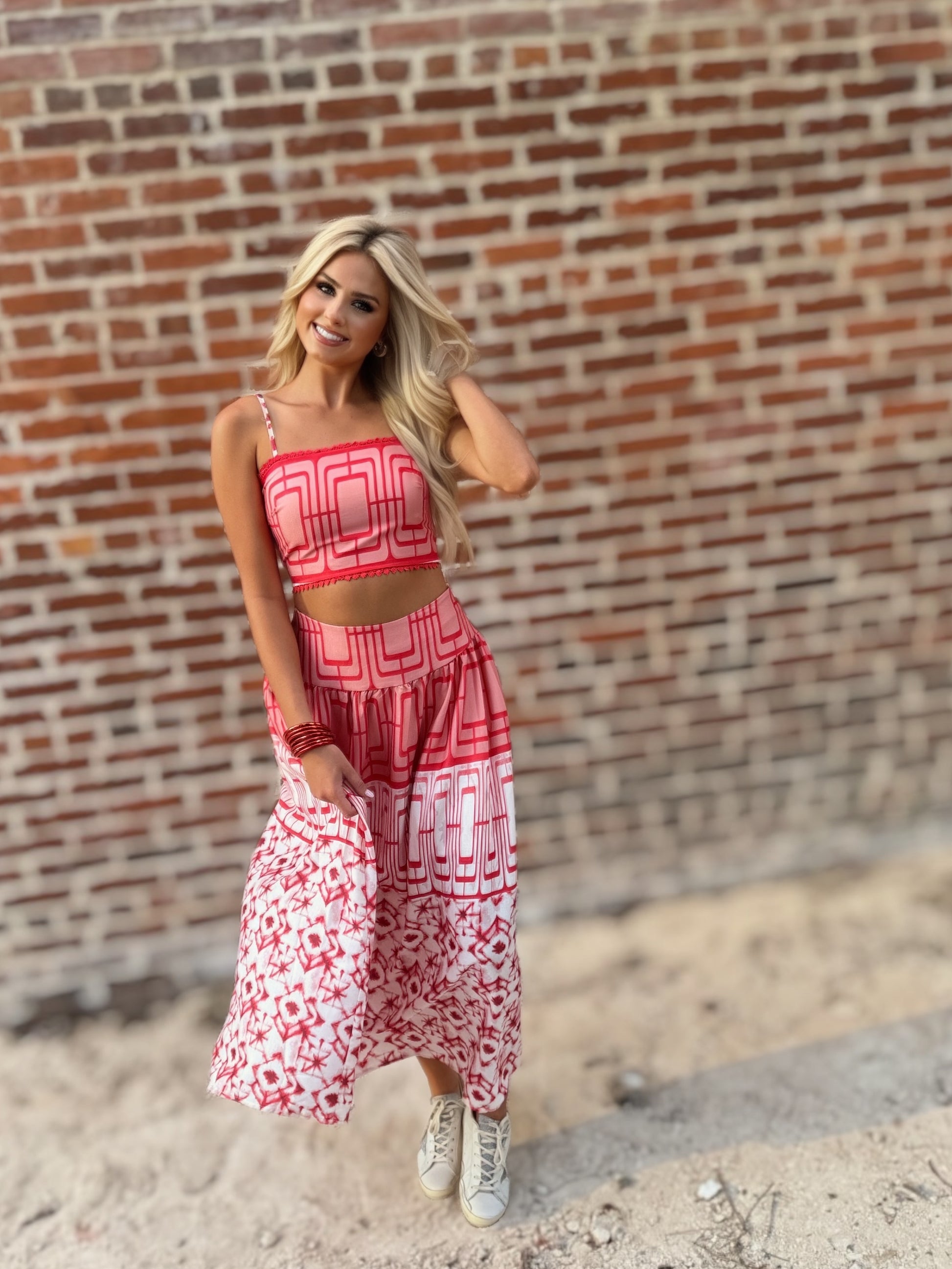 Woman wearing the Retro Red and white geometric crop top and coordinating midi skirt set with white sneakers