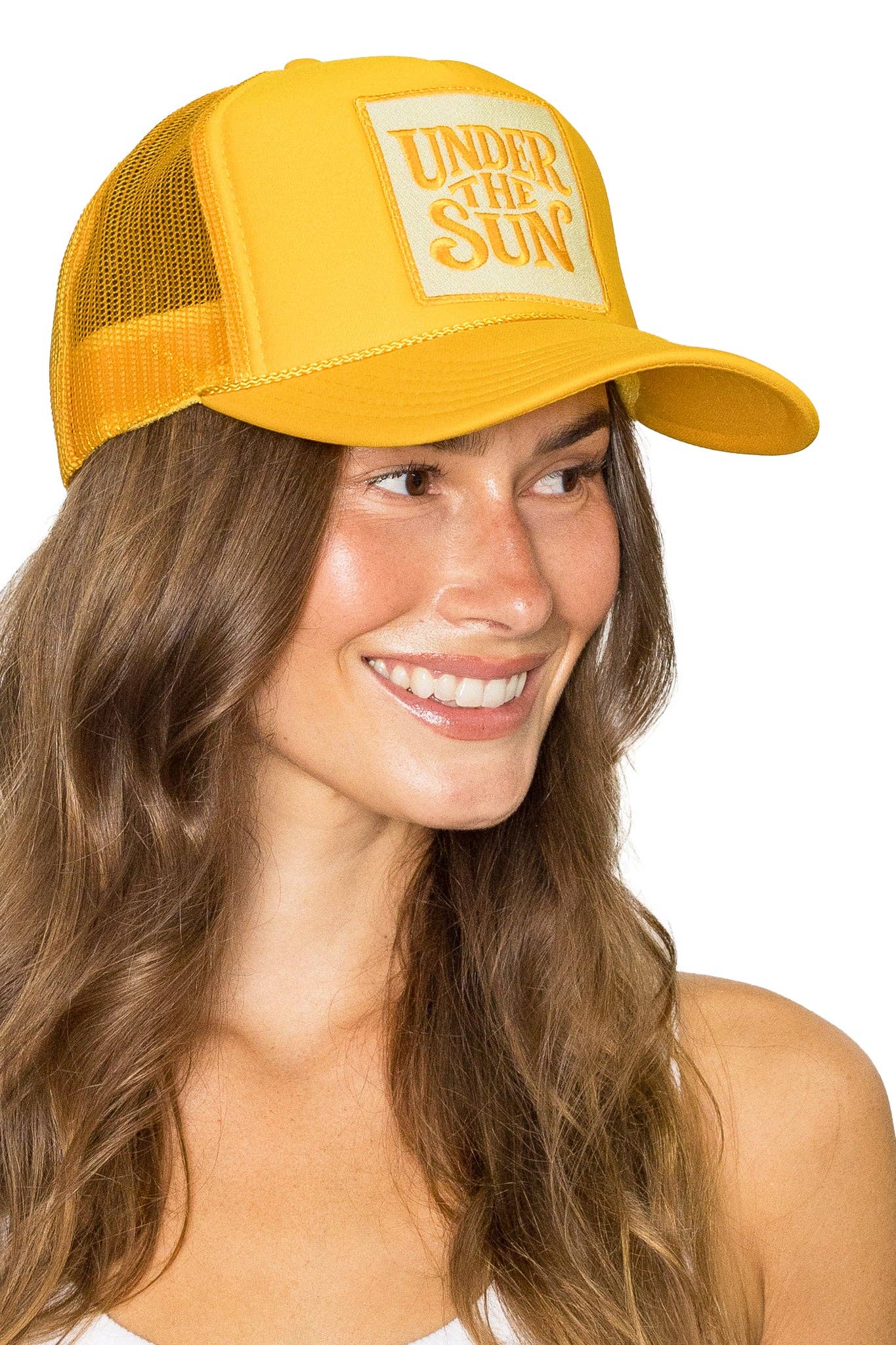 Bright yellow retro trucker hat featuring an embroidered "Under The Sun" patch with breathable mesh back and adjustable snapback design.