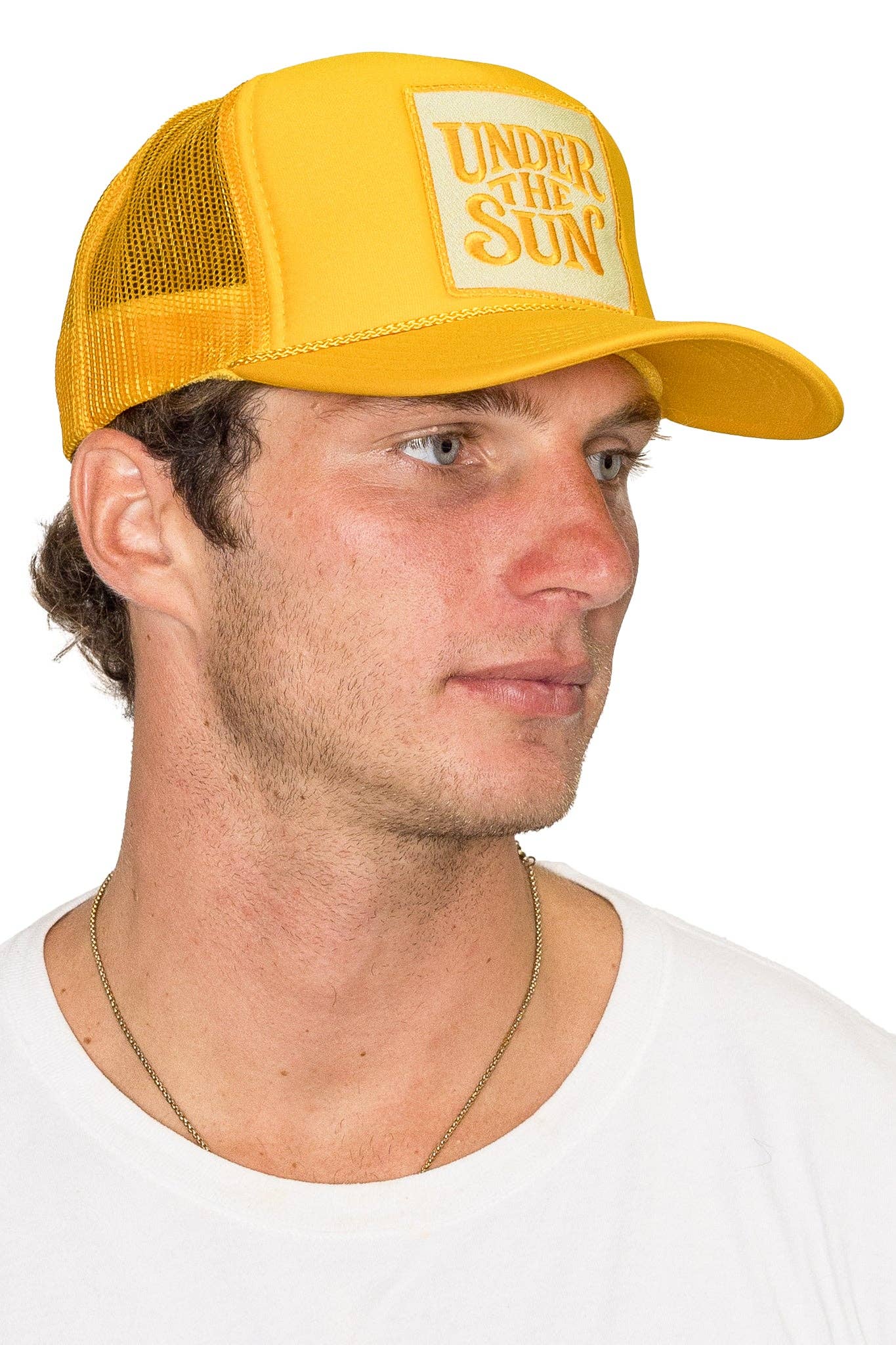 Bright yellow retro trucker hat featuring an embroidered "Under The Sun" patch with breathable mesh back and adjustable snapback design.