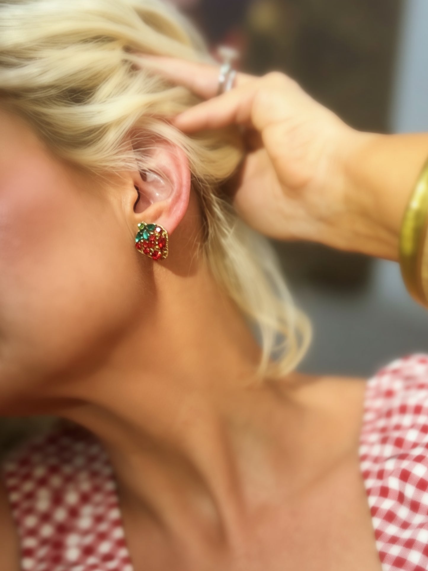 Red and green rhinestone strawberry statement earrings with crystal leaf accents and gold-tone trim displayed on jewelry cards.
