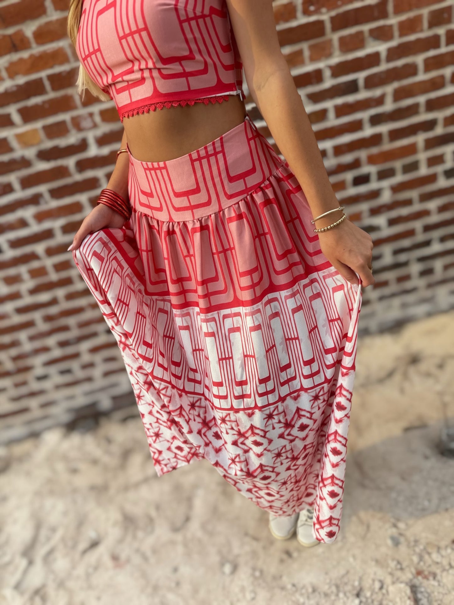 Woman wearing the Retro Red and white geometric crop top and coordinating midi skirt set with white sneakers