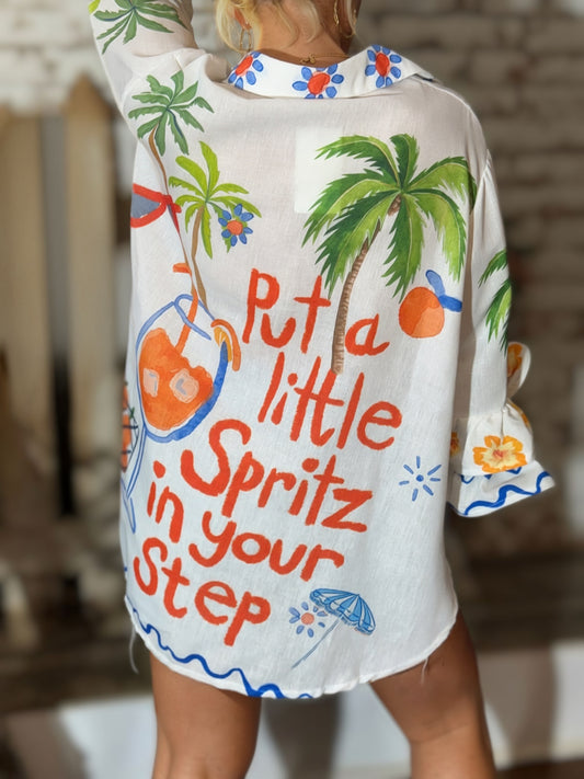 White Italian button-down resort shirt featuring colorful palm trees, citrus artwork, blueberries, and "Put a Little Spritz in Your Step" graphic.