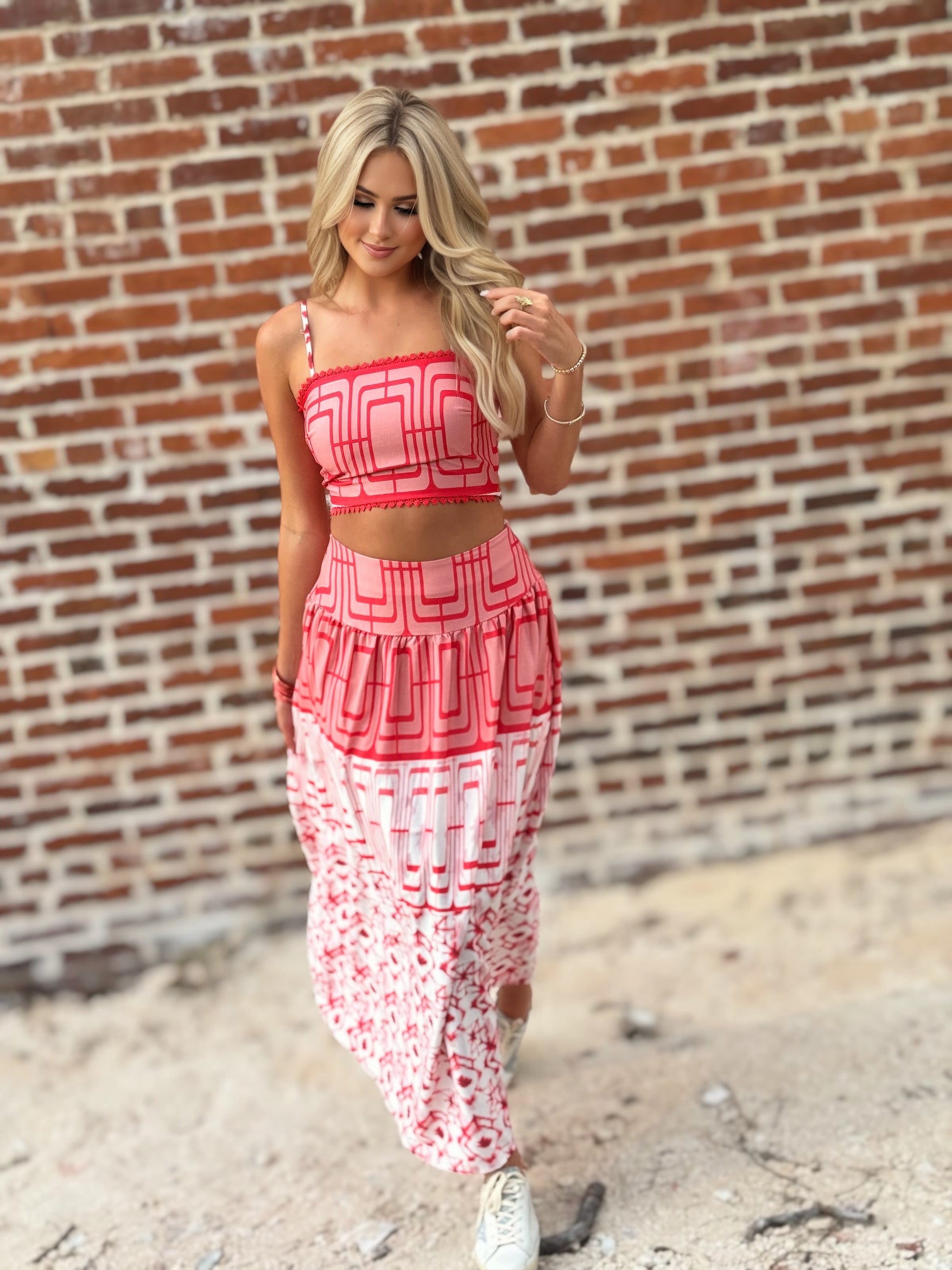 Woman wearing the Retro Red and white geometric crop top and coordinating midi skirt set with white sneakers