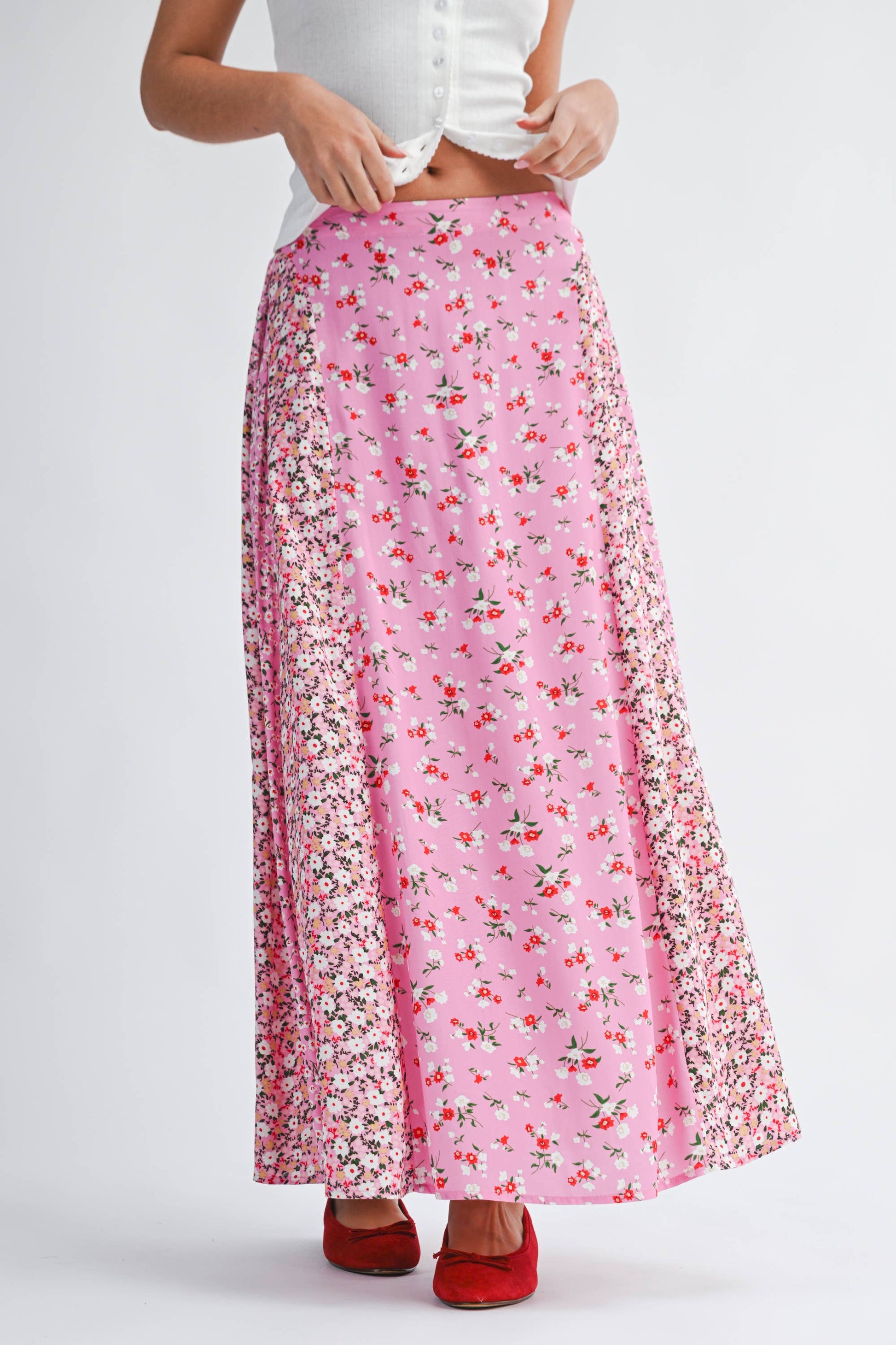 Person wearing a pink floral skirt on a white background