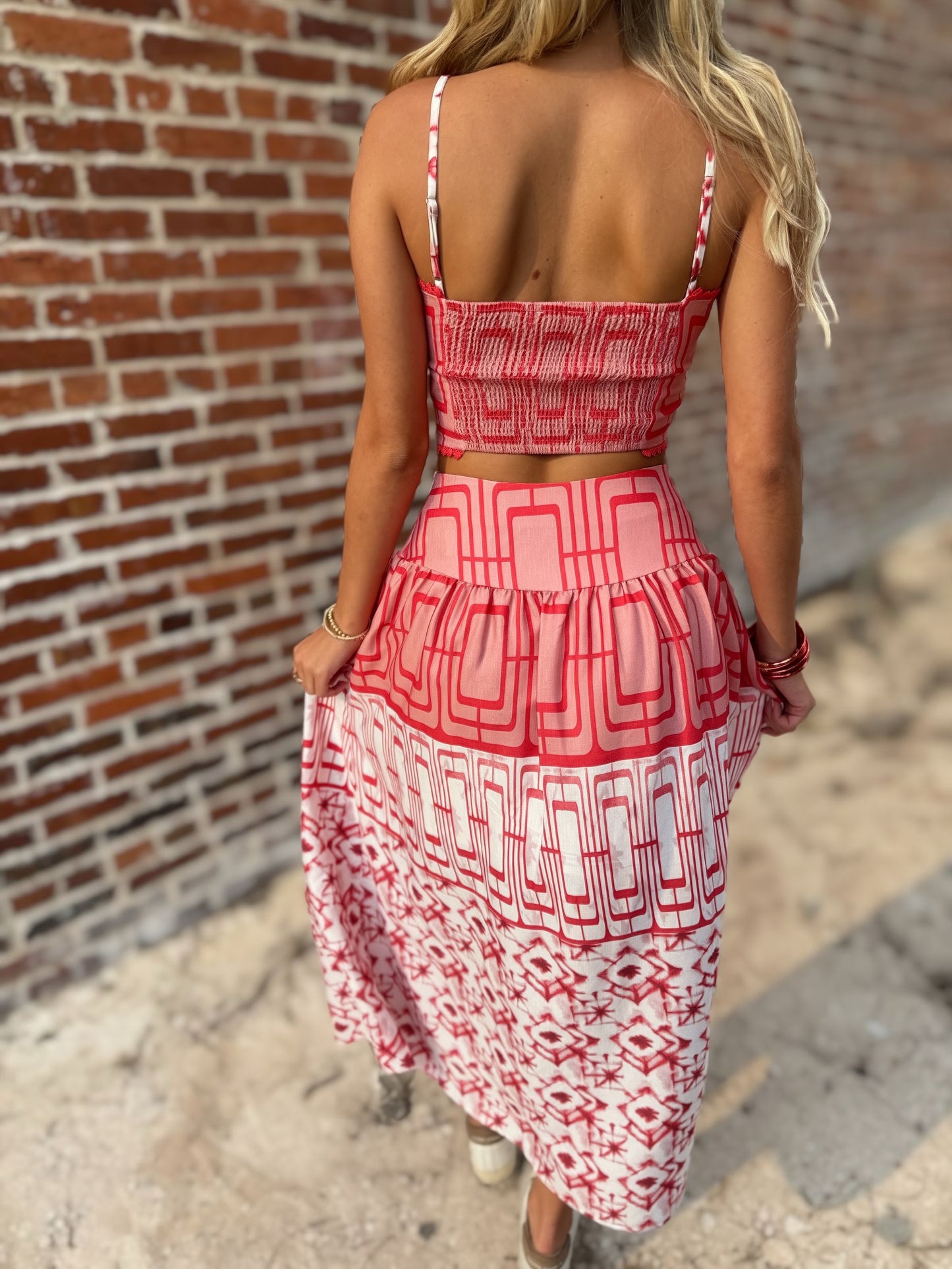 Woman wearing the Retro Red and white geometric crop top and coordinating midi skirt set with white sneakers