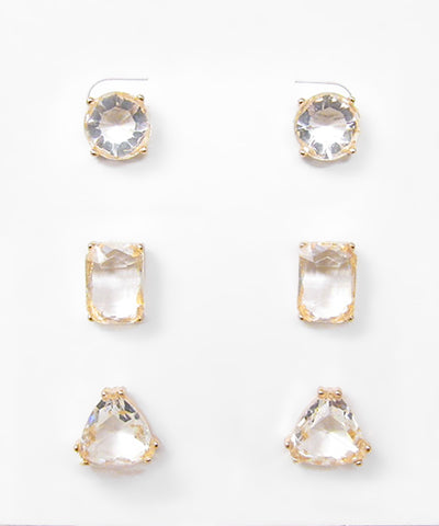 Three pairs of clear faceted glass stud earrings in round, rectangular, and rounded triangular shapes with gold-tone settings.

