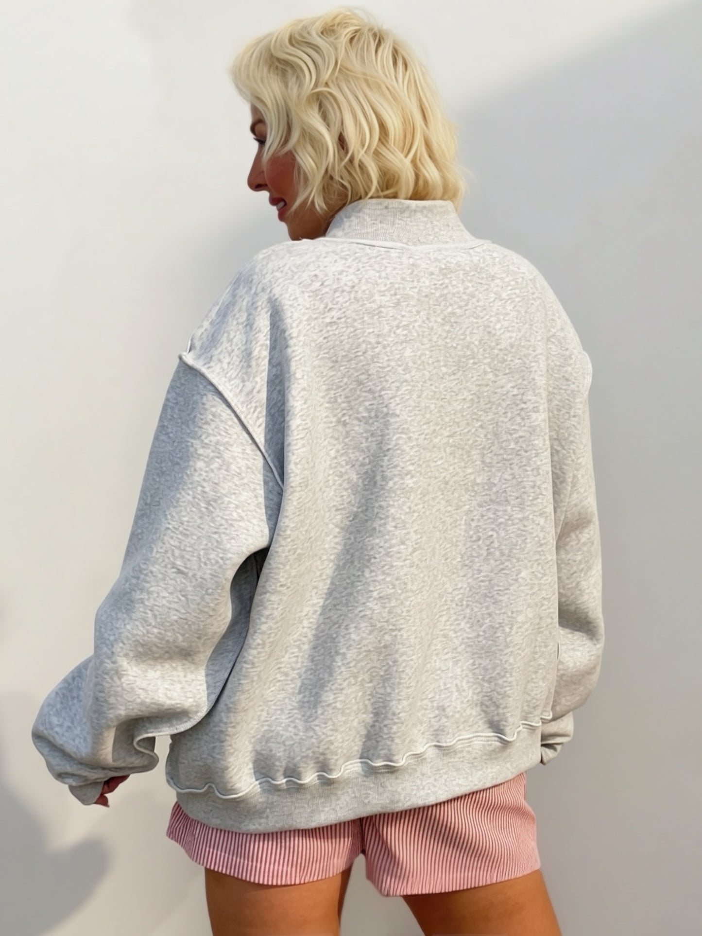 Heather gray oversized mock-neck sweatshirt featuring bold navy polka-dot "FAITH" embroidered lettering on the front