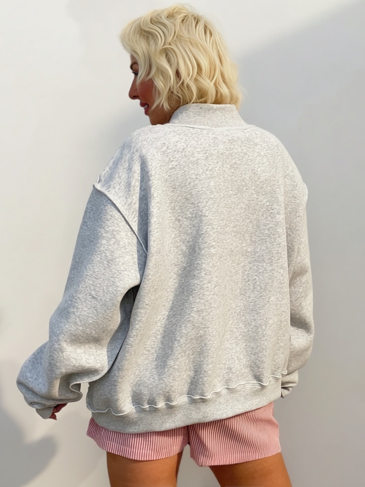 Heather gray oversized mock-neck sweatshirt featuring bold navy polka-dot "FAITH" embroidered lettering on the front
