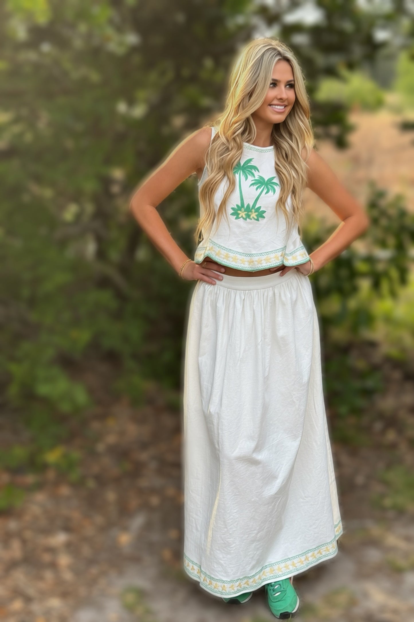 Woman wearing a white dress with palm tree design outdoors