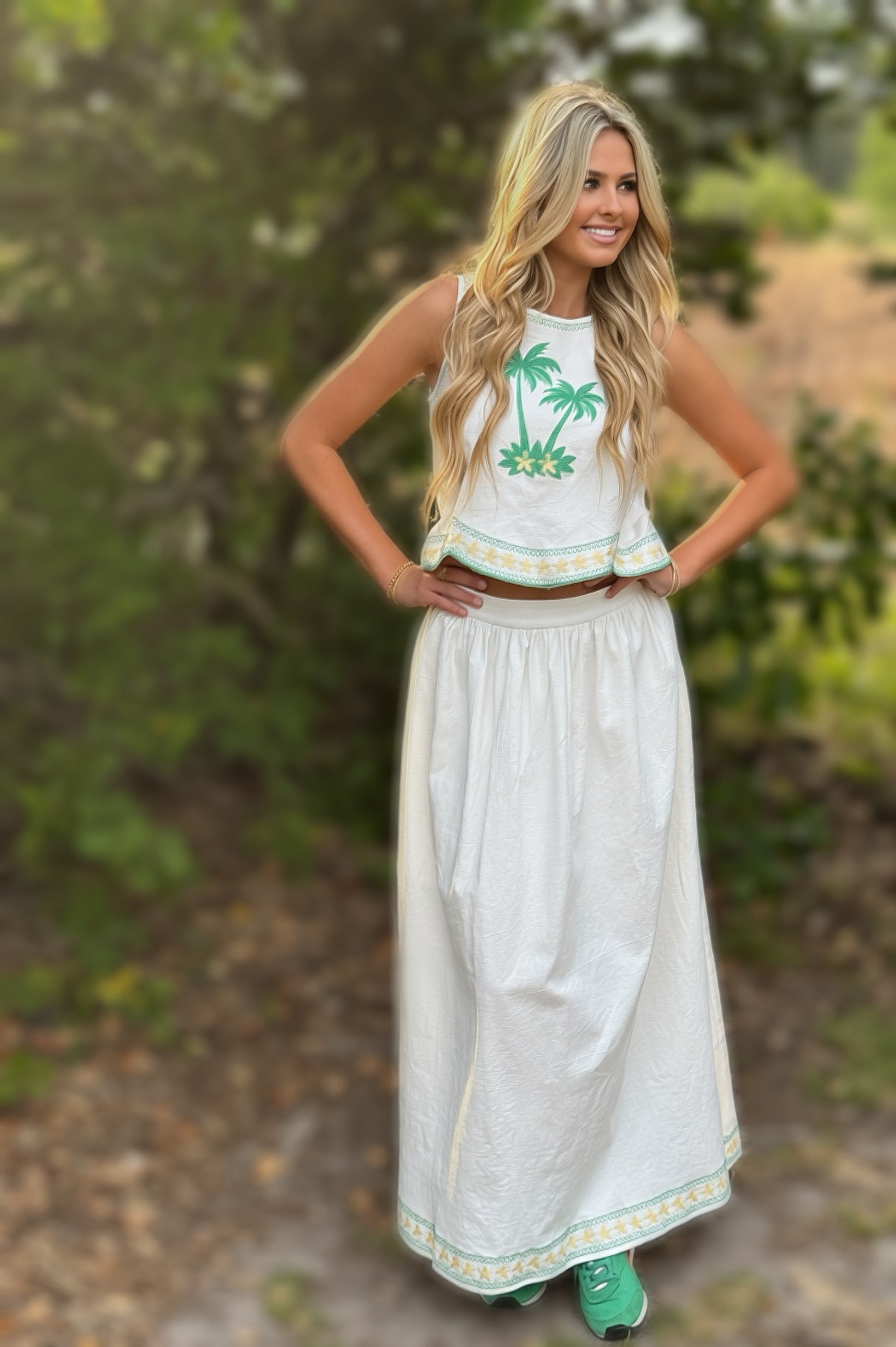 Woman wearing a white dress with palm tree design outdoors