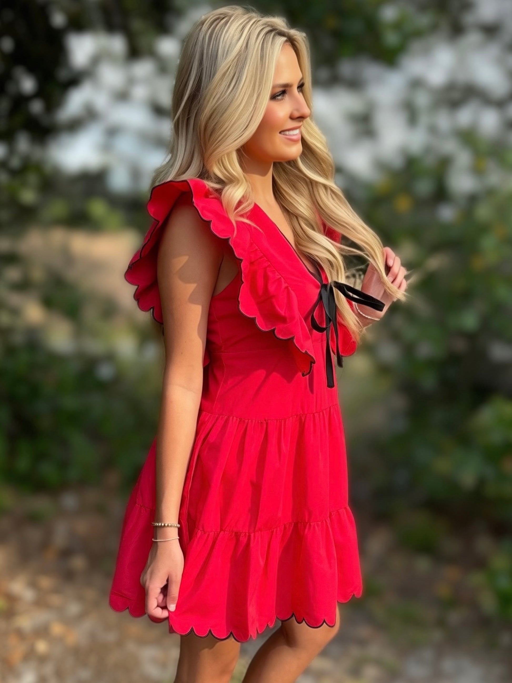 Woman wearing a red dress with ruffled details outdoors