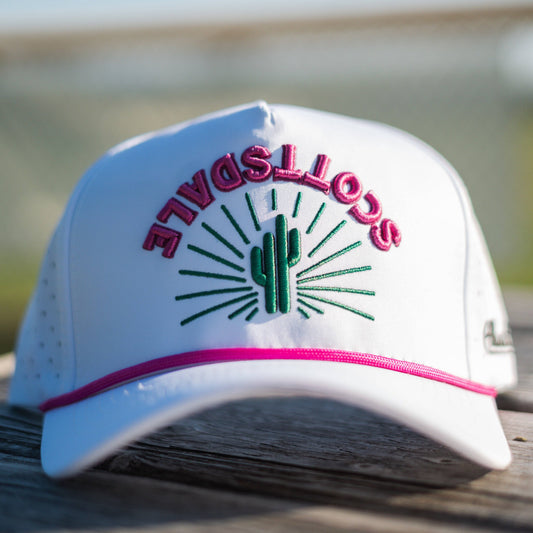 White cap with 'Scottsdale' and cactus design on a wooden surface