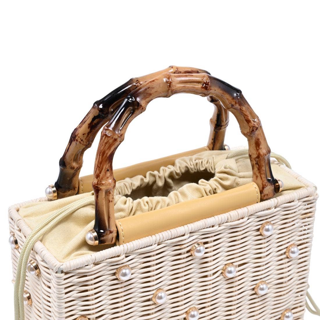 Wicker picnic basket with decorative handle and pearl embellishments on a white background
